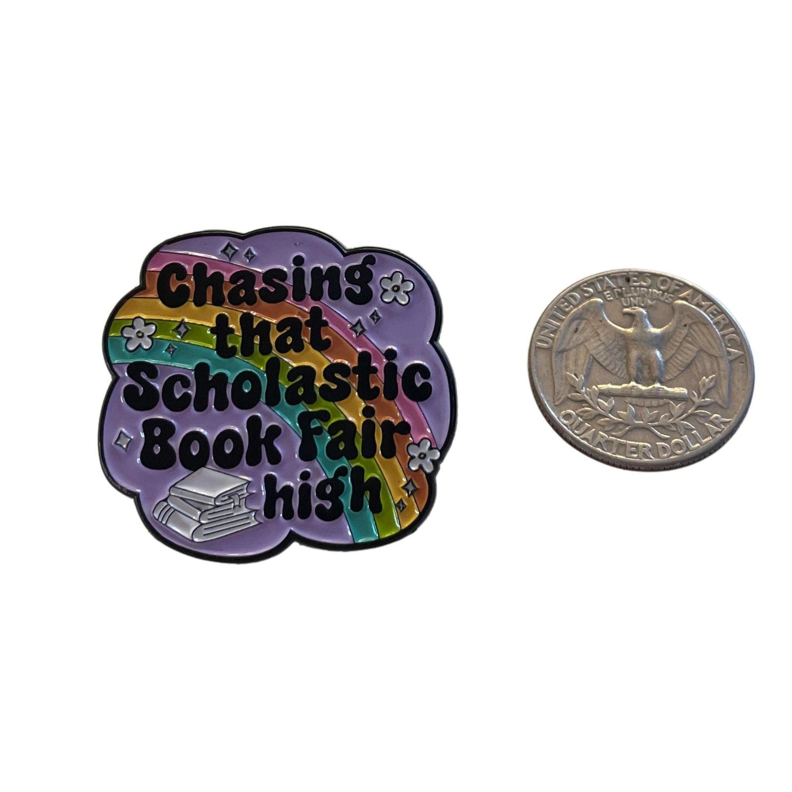 Chasing that Scholastic Book Fair high enamel pin with rainbow background and stack of books design